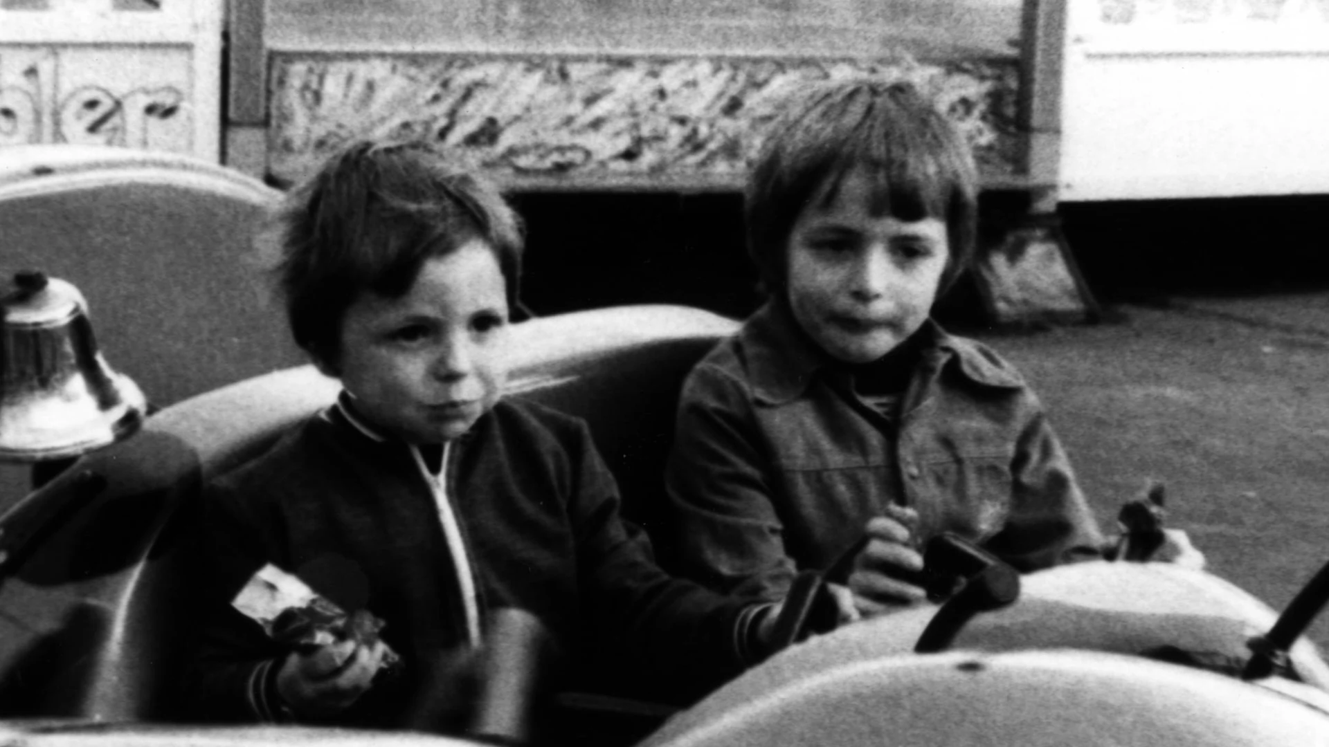 Two young boys on a ladybird ride. Showing a blurry original version, and a restored full colour version.