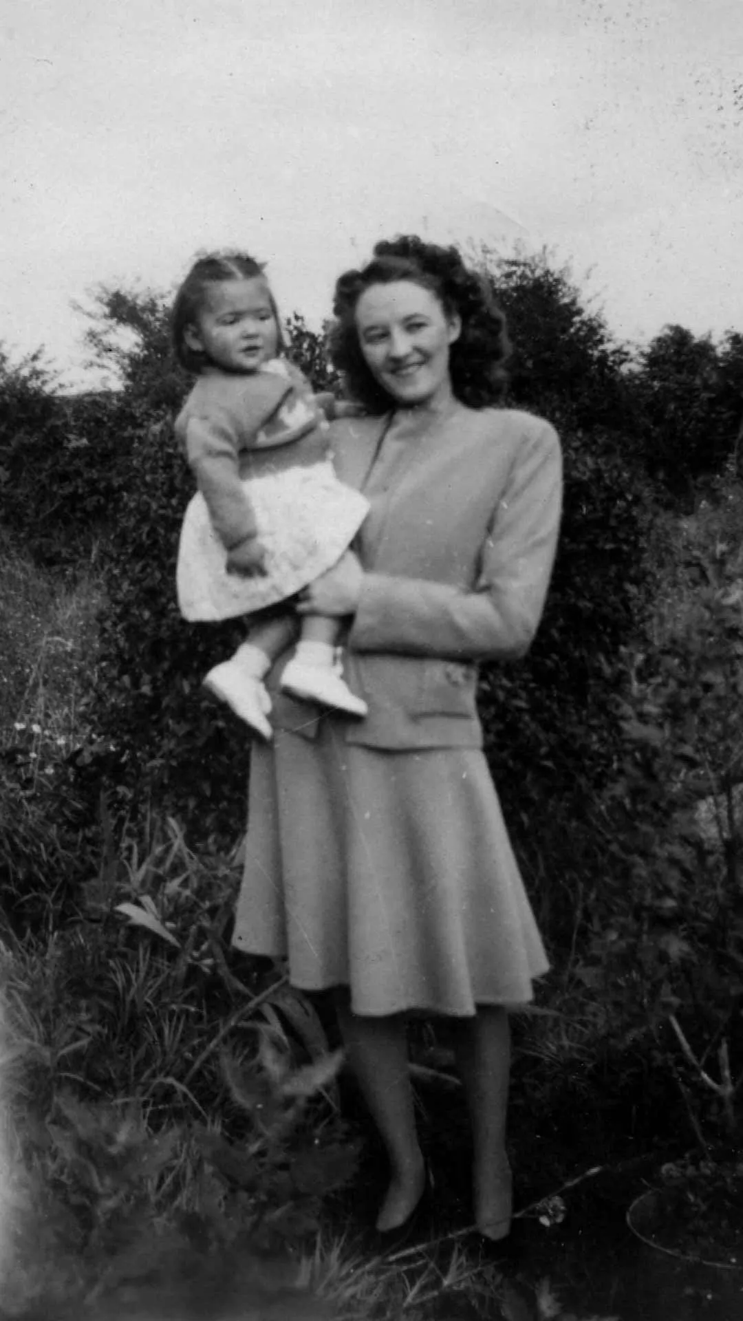 A young girl and her monther in black and white. And a full colour restored version